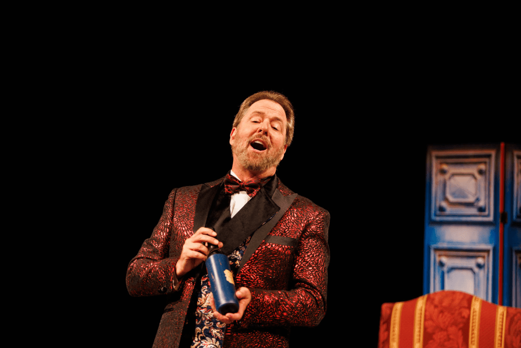 Dulcamara (Blake Davidson) shows off one of his elixirs in "Udite, udite, oh rustici!" from Donizetti's "The Elixir of Love."